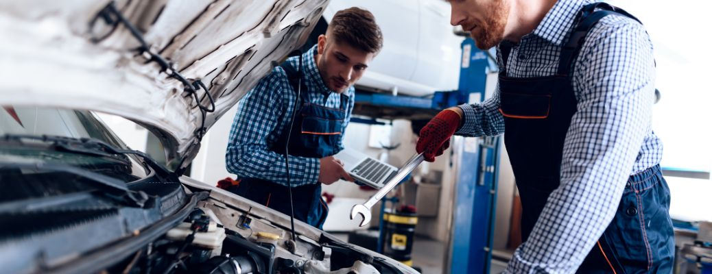 technicians working under the hood of a car