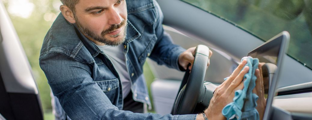 a technician cleaning the infotainment system of a car