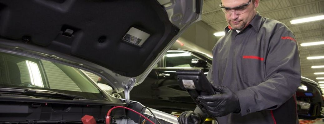 a technician inspecting a car's battery