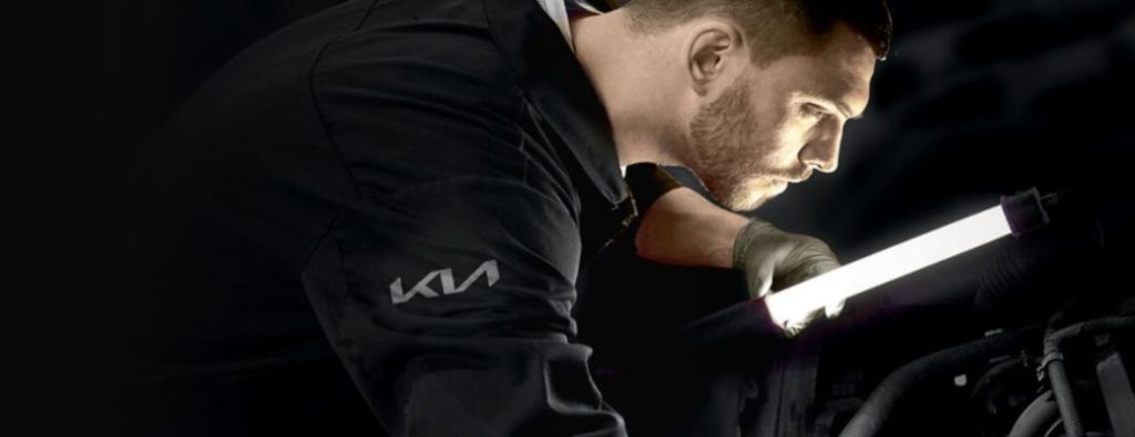 close up of a Kia technician holding a flashlight