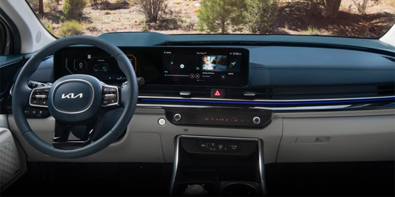 Interior view of a modern car dashboard with a sleek steering wheel, digital screens, and controls, indicating technology.