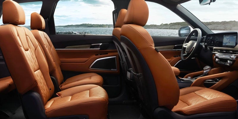 Interior of a car with light brown leather seats. The dashboard and steering wheel are visible in the foreground.