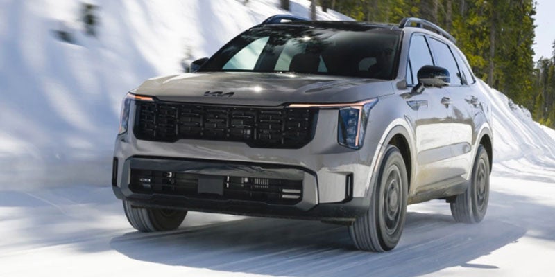 Front view of a 2026 Kia Sorento with inset shots of the gear selector and tan leather seating.