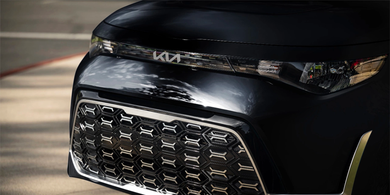 Close front view of a Kia Soul’s grille and headlight area in black.