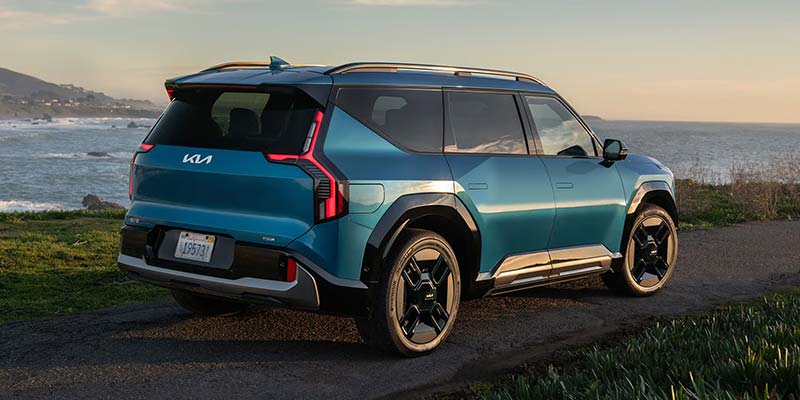 Kia EV9 parked near a coastal landscape.