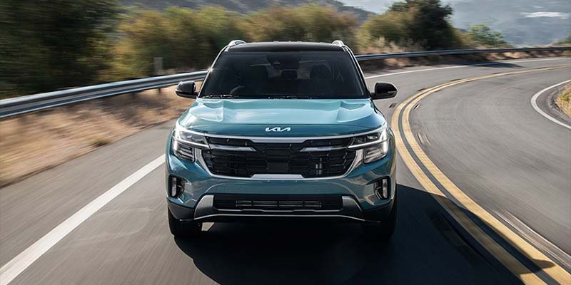 Front view of a Kia Seltos driving on a winding road.